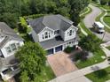 Aerial view of a two-story home with a brick driveway, backyard patio and a lush green lawn at 5095 Southlawn Ave, Orlando, FL 32811