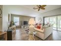 Cozy living room with a large TV, comfortable sofas, and access to the patio at 17567 Se 81St Parnassus Ct, The Villages, FL 32162