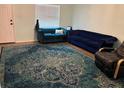 Cozy living room featuring a blue accent rug, plush sofas, and natural light from the window at 3439 Swindell Rd, Lakeland, FL 33810