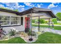 Close-up of the front entrance, showcasing a modern red door and decorative rain chains at 223 Pinehurst Dr, Auburndale, FL 33823