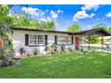 A cozy single-story home featuring a vibrant green lawn, complemented by landscaped flower beds at 223 Pinehurst Dr, Auburndale, FL 33823