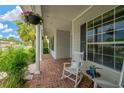 Charming covered front porch with brick flooring, decorated with potted plants and rocking chairs at 2973 Blackwater Creek Dr, Lakeland, FL 33810