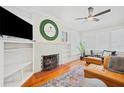 Bright living room featuring hardwood floors, a decorative fireplace, and built-in shelving at 739 Park Hill Ave, Lakeland, FL 33801