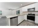 Modern kitchen features granite countertops, stainless steel appliances, and gray wood flooring at 3228 Seville St, Lake Alfred, FL 33850