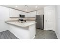 Bright kitchen with granite countertops, stainless steel appliances, and gray wood flooring at 3228 Seville St, Lake Alfred, FL 33850
