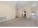 Bright and airy living room showcasing plush carpeting, neutral paint, vaulted ceilings, and modern lighting fixtures at 3243 Winchester Estates Cir, Lakeland, FL 33810