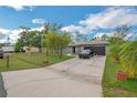 Exterior shot of home with two-car garage, concrete driveway, lush landscaping, and mature trees at 107 Talavera Ln, Kissimmee, FL 34758