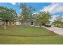 Traditional-style home featuring a well-manicured lawn and mature trees that create a welcoming curb appeal at 107 Talavera Ln, Kissimmee, FL 34758