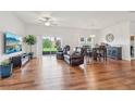 Bright and airy living area featuring hardwood floors, neutral paint, and sliding door access to the outdoors at 448 Sorrento Rd, Kissimmee, FL 34759