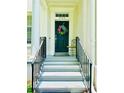 Close-up of the front door featuring decorative wreath, elegant columns, and steps leading to the entrance at 5489 Baldwin Park St, Orlando, FL 32814