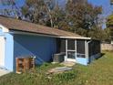 Back exterior view with a screened in porch, along with an AC unit and miscellaneous items at 1257 Dal Maso Dr, Daytona Beach, FL 32117