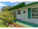Inviting front entrance with cheerful Welcome sign and vibrant flowering bushes at 2825 Woodcrest Ln, Lakeland, FL 33805