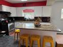 Bright kitchen featuring an island with granite countertops and stylish yellow stools at 3435 Swindell Rd, Lakeland, FL 33810