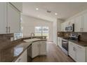 Bright kitchen featuring stainless steel appliances, granite countertops, and sleek white cabinetry at 4444 Withrowwood Ct, Orlando, FL 32837
