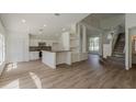 Open-concept living space with a modern kitchen, elegant staircase, and abundant natural light at 4444 Withrowwood Ct, Orlando, FL 32837