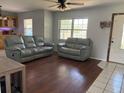 Comfortable living room with wood floors, a ceiling fan and a mix of tile and wood flooring at 3453 Duff Rd, Lakeland, FL 33810
