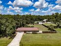 Aerial view of a single story home on a large lot, showcasing the home and surrounding greenery at 6909 Farris Dr, Lakeland, FL 33811