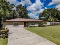 Charming single-story home showcasing a well-manicured lawn and a welcoming driveway at 6909 Farris Dr, Lakeland, FL 33811