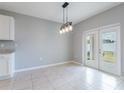Bright dining room with a modern light fixture and double doors that open to the backyard at 3079 Bethpage Loop, Mount Dora, FL 32757