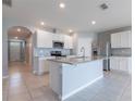 Open kitchen featuring an island, stainless steel appliances, granite countertops and white cabinets at 3079 Bethpage Loop, Mount Dora, FL 32757