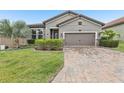 Beautiful home featuring well-maintained landscaping and a brick driveway at 4235 Prima Lago Dr, Lakeland, FL 33810