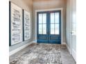 Inviting foyer with elegant double doors, stylish rug, and sophisticated artwork at 12902 Sw 138Th Loop, Dunnellon, FL 34432