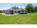 Charming blue home with well-manicured lawn, patio, and lush landscaping at 3229 Gardner Oaks Ln, Lakeland, FL 33810