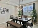Bright dining area featuring a modern chandelier, large window, and elegant decor at 4751 Clock Tower Dr # 307, Kissimmee, FL 34746