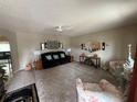 Cozy living room featuring a comfortable sofa, plush carpeting and neutral walls at 17569 Se 107Th Ct, Summerfield, FL 34491