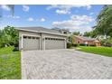 Spacious three-car garage with a patterned driveway and well-maintained landscaping at 297 Beacon Pointe Dr, Ocoee, FL 34761