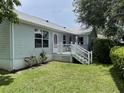 Home's rear view featuring a cozy back porch and well-kept lawn at 508 Alcazar Ct, Lady Lake, FL 32159