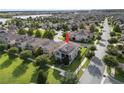 Aerial view of a house with solar panels in a neighborhood, featuring a well-manicured lawn at 16324 Brisk Breeze Aly, Winter Garden, FL 34787
