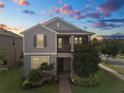 Charming two-story home with a landscaped yard, covered porch, and gray exterior at sunset at 16324 Brisk Breeze Aly, Winter Garden, FL 34787