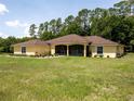 Lovely one story home with a well-maintained lawn, lush greenery, and a screened-in porch at 21590 Sw 84Th Loop, Dunnellon, FL 34431