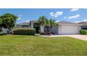 Front exterior of well maintained home with green grass and mature plants. Includes two car garage and grey trim at 2869 Hickory Ridge Dr, Lakeland, FL 33813