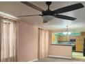 Cozy living room with a ceiling fan and view into kitchen at 225 N Palmetto Ave, Fort Meade, FL 33841