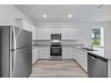 Modern kitchen features stainless steel appliances, granite countertops, and white cabinets at 247 Big Sioux Dr, Poinciana, FL 34759