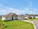 Charming home with a lush green lawn, three-car garage, and inviting curb appeal at 3544 Lakeside Heritage Dr, Lakeland, FL 33812