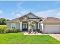 Charming home featuring a manicured lawn, paver driveway, and stone accents at 3544 Lakeside Heritage Dr, Lakeland, FL 33812