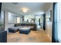 Open living room with view to kitchen, large sectional, and neutral color scheme at 4132 Festival Pointe Blvd, Mulberry, FL 33860