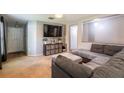 Cozy living room with carpet floors, a large sectional sofa, and a mounted television at 4132 Festival Pointe Blvd, Mulberry, FL 33860