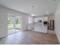 Bright kitchen featuring white cabinets, stainless steel appliances, and an open layout with patio access at 16398 Yelloweyed Dr, Clermont, FL 34714