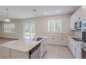 Spacious kitchen with white cabinets, large center island, and stainless steel appliances overlooking backyard at 16398 Yelloweyed Dr, Clermont, FL 34714