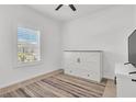 Bright bedroom featuring light wood floors, white walls, and plantation shutters for ample natural light at 2359 White Cedar Way, Haines City, FL 33844