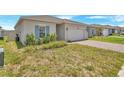 View of a modern single-Gathering home featuring a two-car garage and tidy landscaping at 2359 White Cedar Way, Haines City, FL 33844