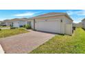 Inviting curb appeal with a brick driveway, two-car garage, and easy-care front yard at 2359 White Cedar Way, Haines City, FL 33844