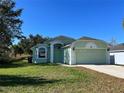 Well-maintained single-Gathering home with an attached two-car garage, nice front lawn, and mature trees offering ample shade at 103 Thornbush Pkwy, Davenport, FL 33837