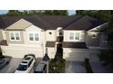 Aerial view of beige two-story townhomes with brown roofs and two-car garages at 1634 Plumeria Pl, Oviedo, FL 32765