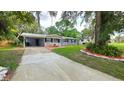 Attractive single-story home boasting a welcoming porch and a driveway leading to a convenient carport at 5834 Forest Grove Blvd, Orlando, FL 32808
