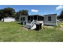 A view of a backyard with a screened-in porch and well-maintained grass at 4861 Myrtle View N Dr, Mulberry, FL 33860